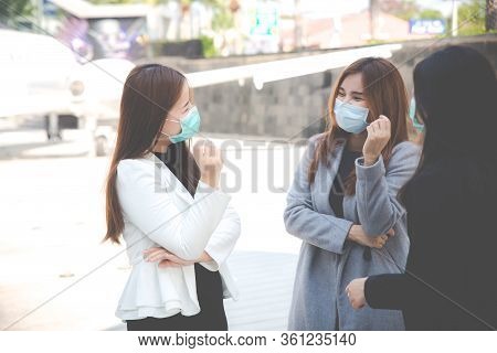 Three Confident Businesswomen Talking And Wearing Face Protection In Prevention For Coronavirus In P