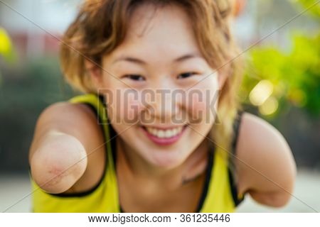 Happy Asian Armless Woman Warming Up Before Swimming At The Tropical Beach