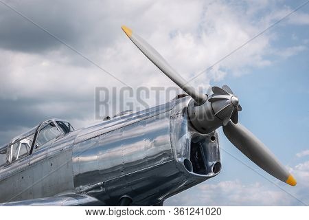 Old Airplane With A Single Engine And Propeller In Front. Close-up On The Front Side, The Cockpit, A