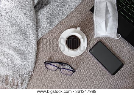 A Laptop, A Medical Mask, Glasses And A Smartphone On A Sofa With A Plaid. Work Or Study From Home, 