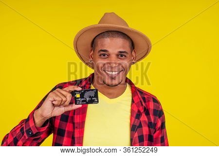 Afro Brazilian Man With Credit Card In Stusio On Yellow Background.farmer Taking A Loan In A Bank Fo
