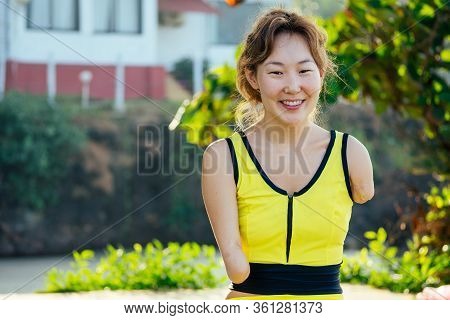 Happy Asian Armless Woman Warming Up Before Swimming At The Tropical Beach