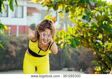 Happy Asian Armless Woman Warming Up Before Swimming At The Tropical Beach