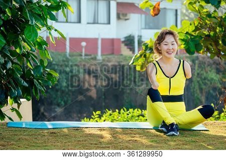 Happy Asian Armless Woman Warming Up Before Swimming At The Tropical Beach
