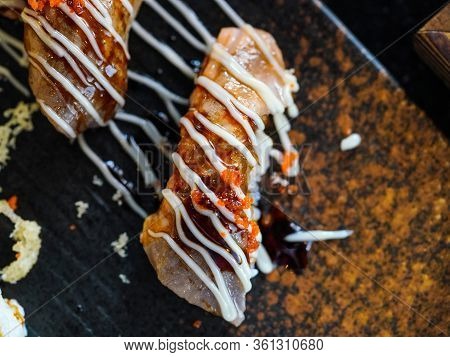 Seared Wagyu Beef Sushi Topped With Mayonnaise And Ebiko Served On A Black Stone Dish. Japanese Cuis