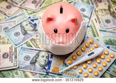Piggy Bank In A Mask On A Background Of American Currency.the Concept Of Coronavrius Epidemic
