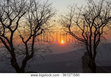 Perugia, Italy - December 9 2016: Sunset Through Tree Branches On Perugia Landscape, Italy