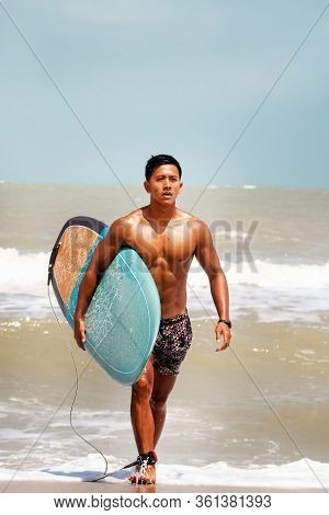 Young Handsome Man Wet All Over Body Holding Serf Board With Right Hand,walking On The Beach,show Fi