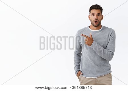 Impressed Handsome Guy Have No Words, Standing Speechless And Amused Pointing Left, Check-out Intere