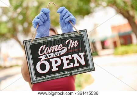 Person Holding Open Sign Outside With Gloves