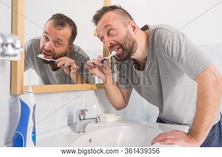 Funnny Guy Taking Care Of His Oral Hygiene, Brushing Teeth During Morning Bathroom Routine.