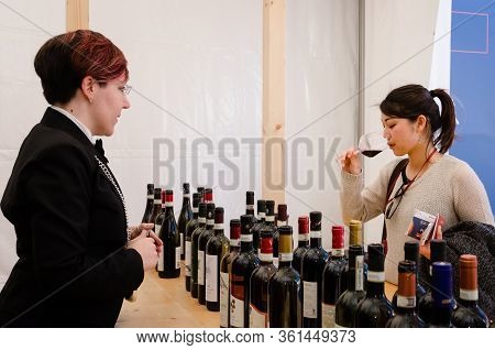 Alba, Italy - April 22, 2017 - Sommelier, And Asian Woman Tasting Traditional Wines Of Piedmont At V