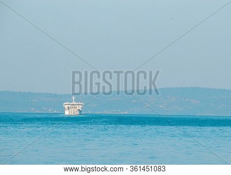 Outline Of A White Ferry Seen In Distance. Blurred Outline As The Ship Dissapears Into The Horizon. 