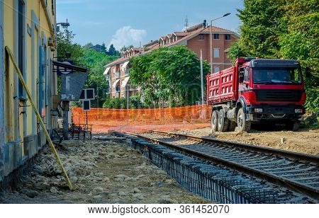 Railway Construction Yard With Truck, Barrier And Old Station