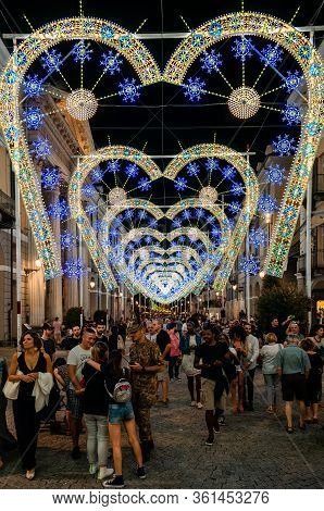 Cuneo, Italy - July 12, 2019: Crowd Walking Under A Light And Music Performance At Night During Cune