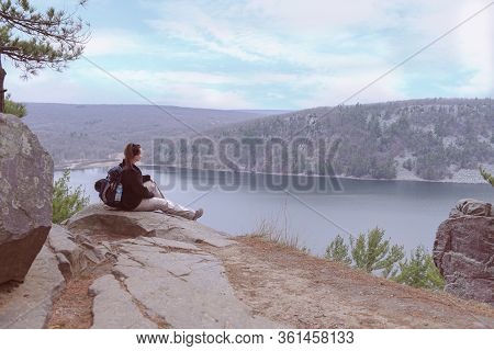 Young Lady Siting On The Rock And Looking For A New Way