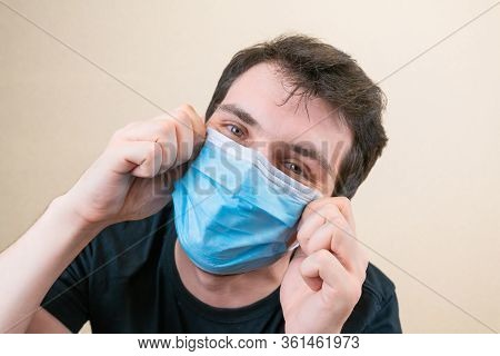 Young Man In Blue Protective Medical Mask And Happu With It. Self-isolation And Quarantine. Stay Hom