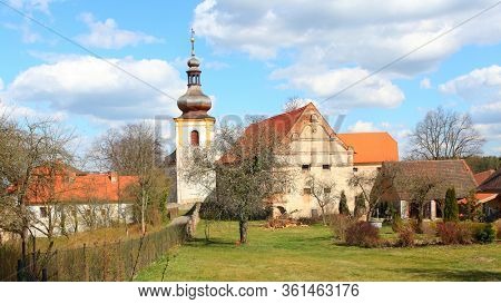 Kadov / Czech Republic - April 10, 2020: Gothic church of St. Wenceslas from the second half of the 13th century and castle in medieval village Kadov in Southern Bohemia.