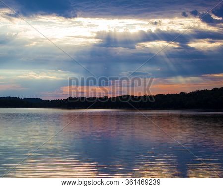 Sun Beams Bursting Form The Clouds Over A Lake