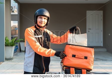 Delivery Asian Man Wearing Orange Uniform And Ready To Send Delivering Food Bag In Front Of Customer