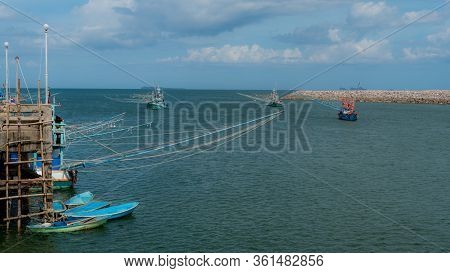 Three Traditional Thai Fishing Boats With Outriggers Out Just Off The Dock In Pythiu On The Gulf Of 