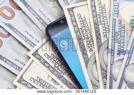Smartphone Screen With Telegram App And Lot Of Hundred Dollar Bills. Business And Social Networking 