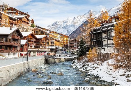 Zermatt, Switzerland - November 11, 2019: Landscape Of Old Town With Rocky Stream Alongside Wooden H