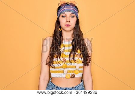 Young beautiful hippie woman with blue eyes wearing accesories and sunnglasses puffing cheeks with funny face. Mouth inflated with air, crazy expression.