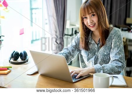 Young Asian Woman Using Laptop And Mobile Phone To Work From Home And Communication Online Internet 