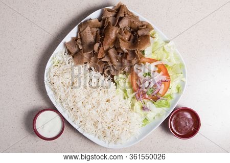 A Fast Food Dish Of Kebab With Rice On A Plate.