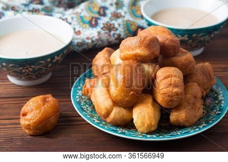 National Cuisine - Uzbek Baursaki In A Plate With A Traditional Pattern, On A Dark Wooden Table. Bas