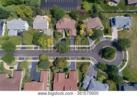 Aerial view of a tree-lined neighborhood in a cul-de-sac in a Chicago suburban city in summer.