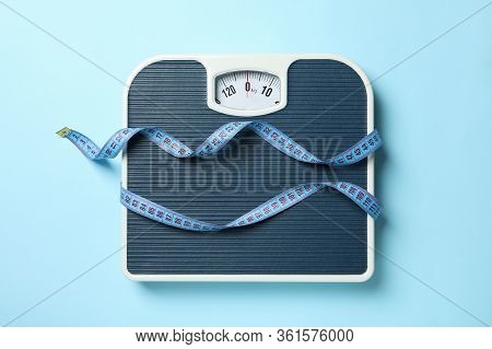 Scales And Measuring Tape On Blue Background. Weight Loss Concept