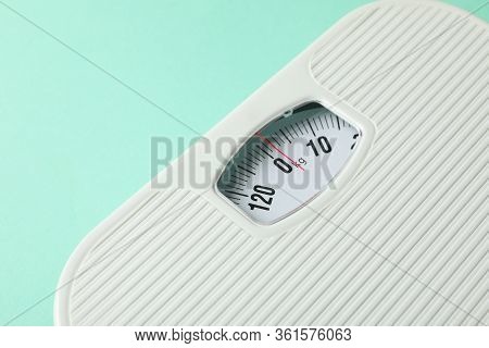 White Scales On Mint Background. Weight Loss Concept