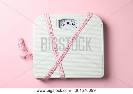 Scales And Measuring Tape On Pink Background. Weight Loss Concept