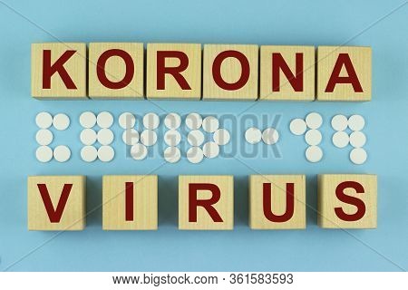 The Korona Virus Is Written On Wooden Cubes And The Inscription Covid19 Of White Tablets On Blue Bac