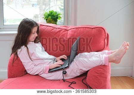 Preteen Girl Enjoyes Homeschooling Or Video Call In Comfy Pajama And Cozy Sofa Chair. Remote Educati