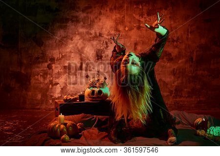 Close Up Portrait Of Beautiful Sexy Witch With Halloween Makeup. Red And Black Face Painting.