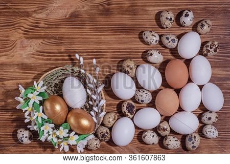 Easter Eggs In Basket Filled With Straw And Yellow Flowers And Willow On Wooden Rustic Vintage Backg
