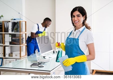 Portrait Of A Happy Female Janitor With Cleaning Equipment In Office