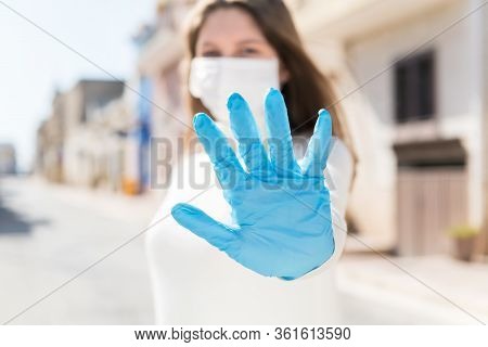 Stay At Home. Covid-19 Quarantine. A Girl In Protective Mask And Gloves Blocks Corona Virus. Social 