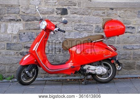 Montreal, Canada - October 27, 2019 - A Bright Red Vespa Scooter Parked On The Street