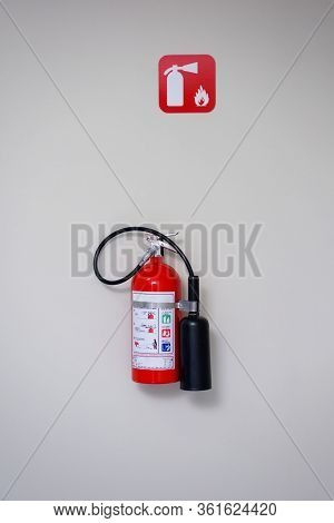 Fire Extinguisher And Fire Department Sign On A White Wall.