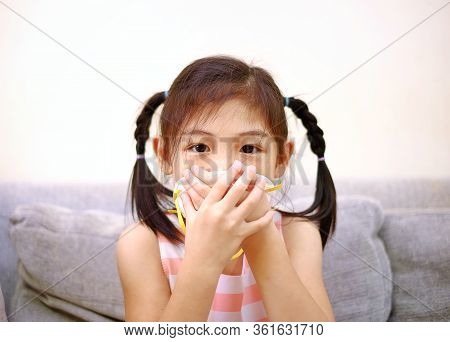 A Pretty Asian Girl Covering Her Mouth Using A Mask To Protect Her From Pollution