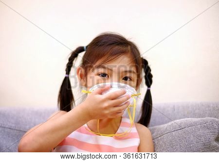 A Pretty Asian Girl Covering Her Mouth Using A Mask To Protect Her From Pollution