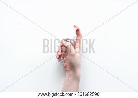 Female Hand Holding Antibacterial Alcohol Spray On White Background Top View. Disinfecting Hands, Co