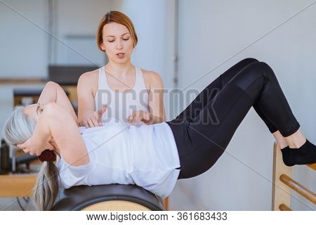 Young Femwle Professional Instructor Helping Her Elderly Woman Clent
