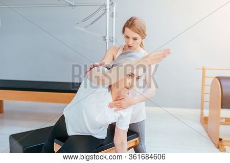 Pilates Lesson On Reformer, Personal Coach In Black Sportswear Workout With Sporty Eldery Beautiful 