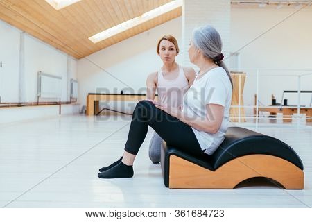 Pilates, Fitness, Sport, Training And People Concept - Woman Doing Exercises On Small Barrel.