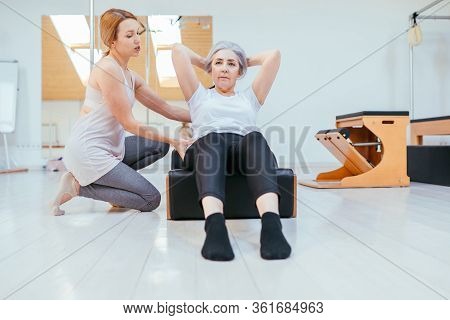 Pilates, Fitness, Sport, Training And People Concept - Woman Doing Exercises On Small Barrel.